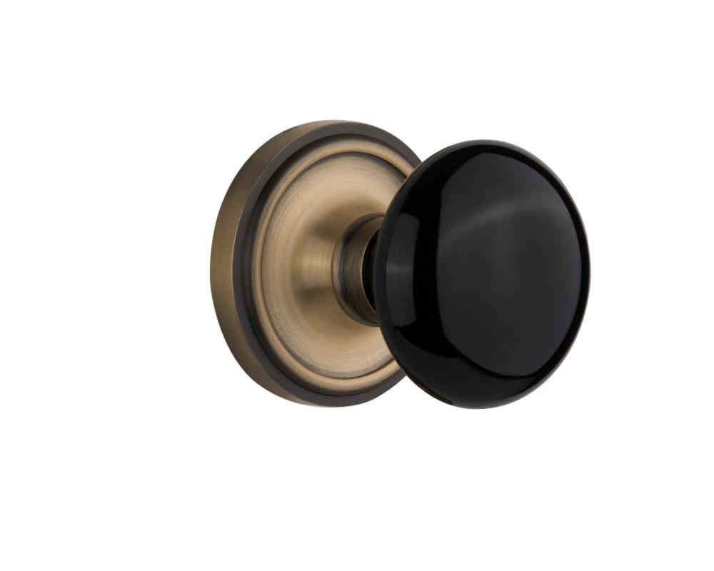 Nostalgic Warehouse Classic Rosette Passage Black Porcelain Door Knob in Antique Brass