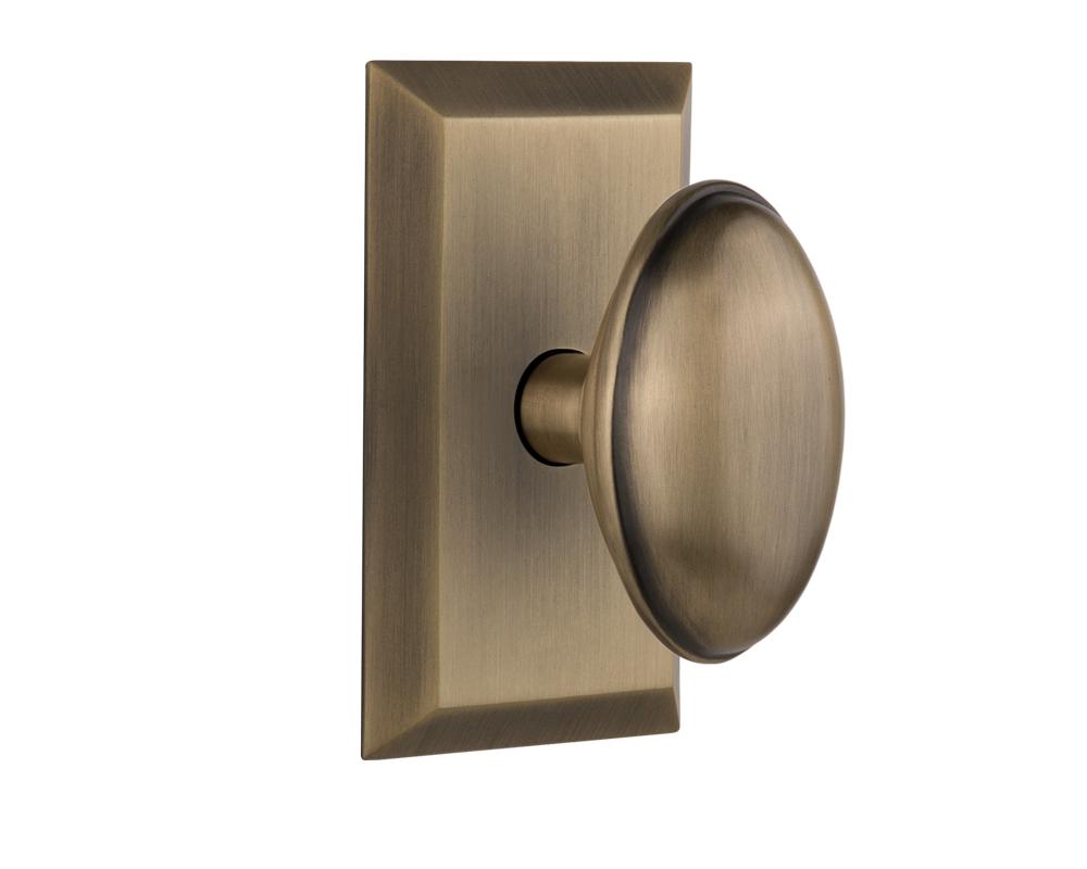 Nostalgic Warehouse Studio Plate Privacy Homestead Door Knob in Antique Brass